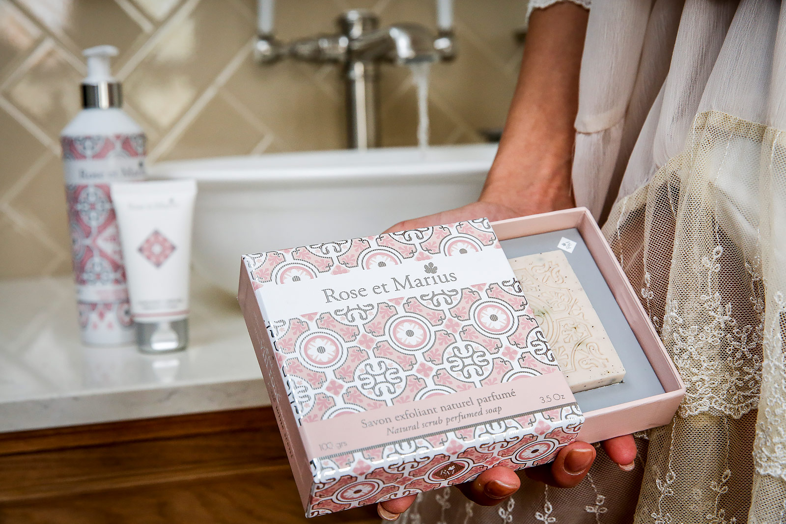 Produits cosmétiques pour le corps de la marque Rose et Marius mise en scène devant le lavabo d'une salle de bains, capturé par le photographe produits Denis Dalmasso.